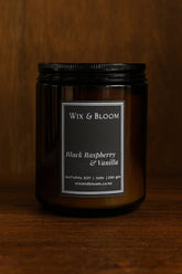 Black candle jar with 'Wix & Bloom' label on a wooden background