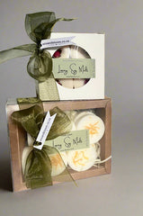 Set of luxury soy melts with green ribbons and packaging on a gray background