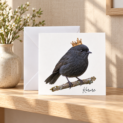 “Karure black robin greeting card featuring a dark charcoal bird wearing a golden crown.  Bird of the Year 2026