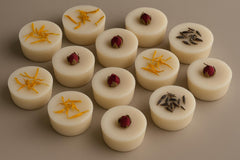 Small round soap bars with decorative elements on a brown background